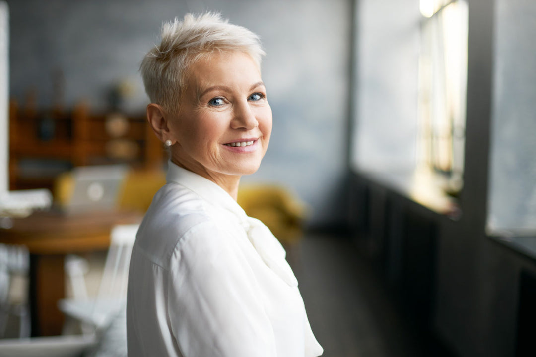 Smiling mature woman with short hair indoors.
