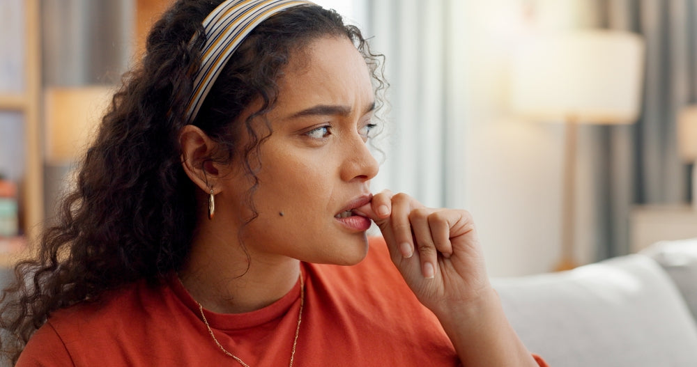 Young biracial woman biting her nails in anxiety